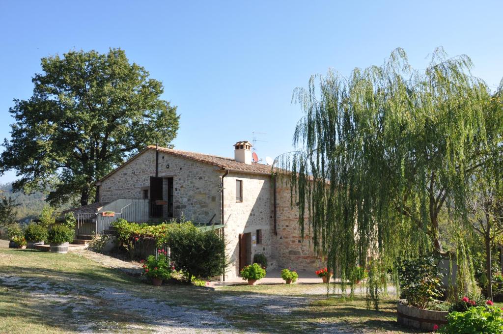 stary kamienny dom z drzewem przed nim w obiekcie Sarteano Country Villa w mieście Sarteano