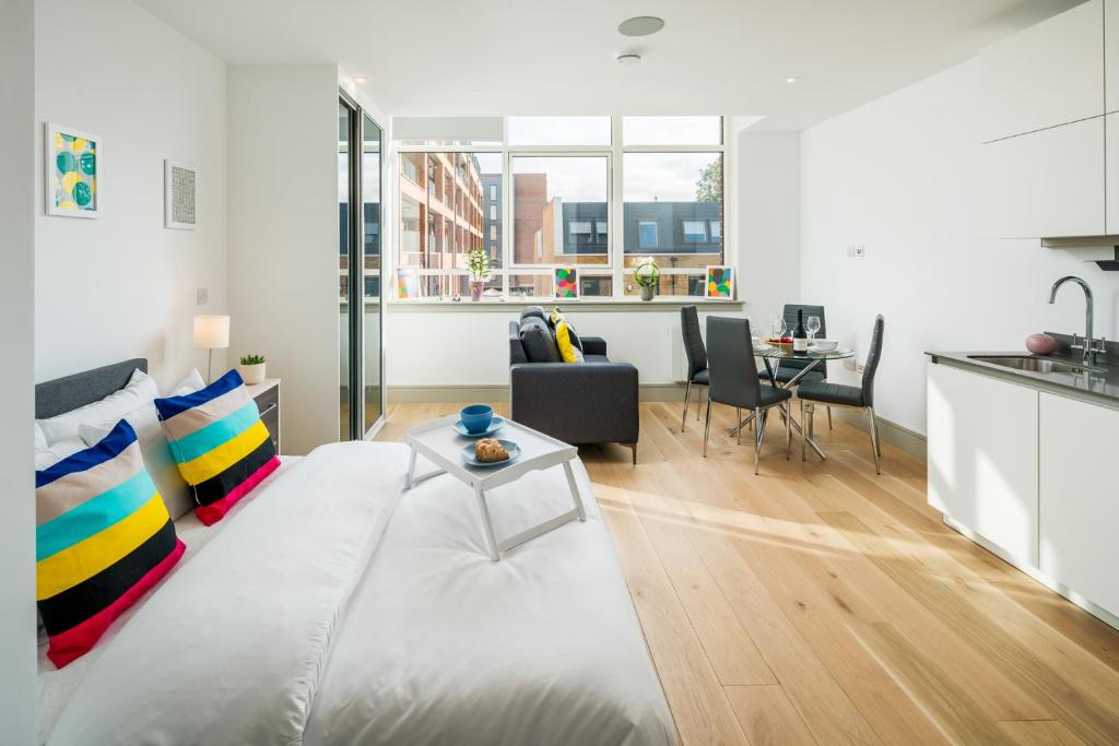 uma sala de estar com uma cama grande e uma mesa em Regents North London Apartments em Londres