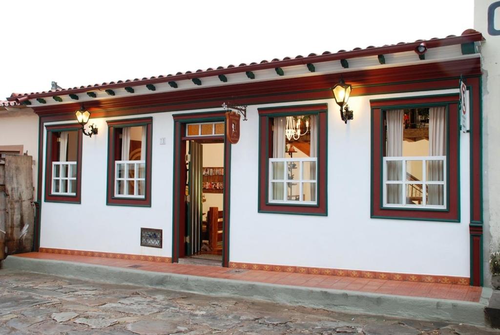 a white building with windows and a door at Pousada Vila do Imperador in Diamantina