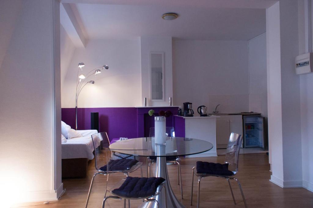 a dining table and chairs in a living room at Les studios de la grand Place in Tournai