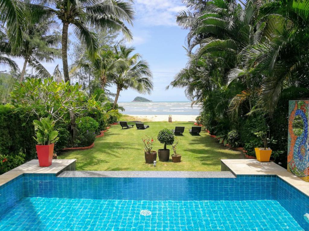 a pool with a view of the beach and the ocean at Villa Manipura in Ko Chang
