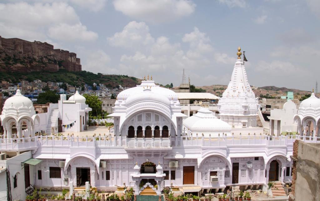 a white temple with a hill in the background at Nirvana Home in Jodhpur