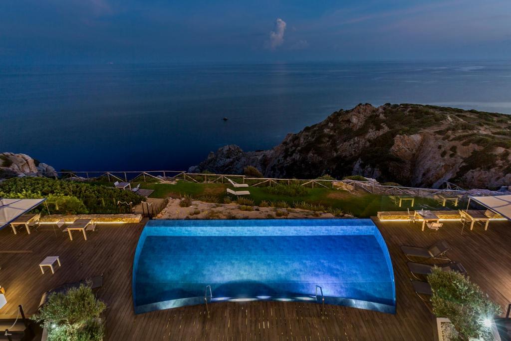 a large swimming pool with a view of the ocean at Faro Capo Spartivento in Chia