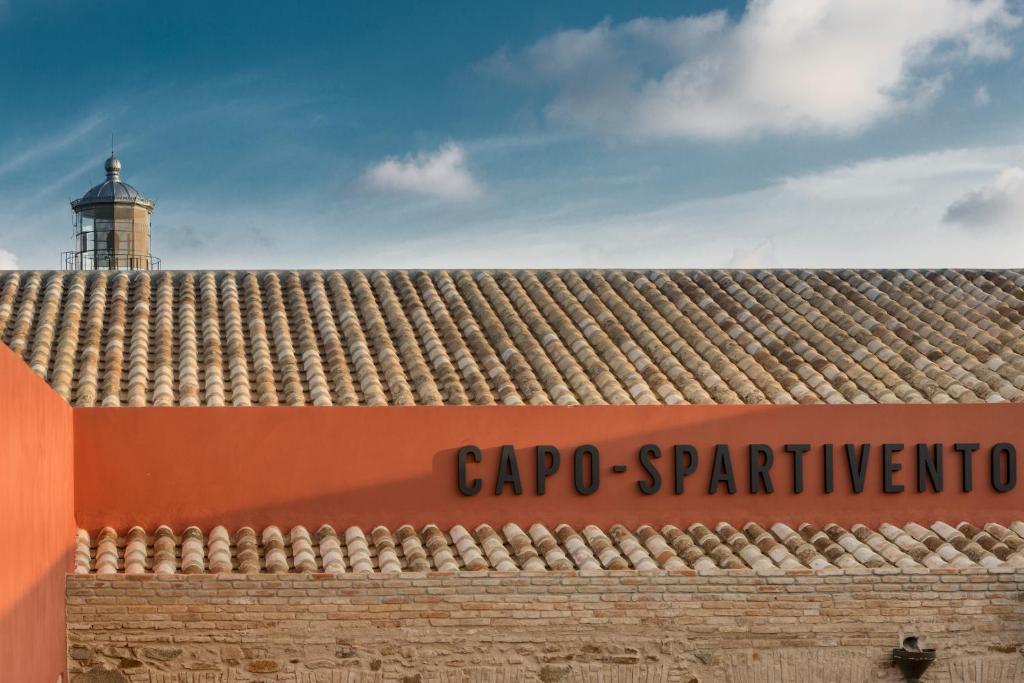 a sign on top of a building with a lighthouse at Faro Capo Spartivento in Chia