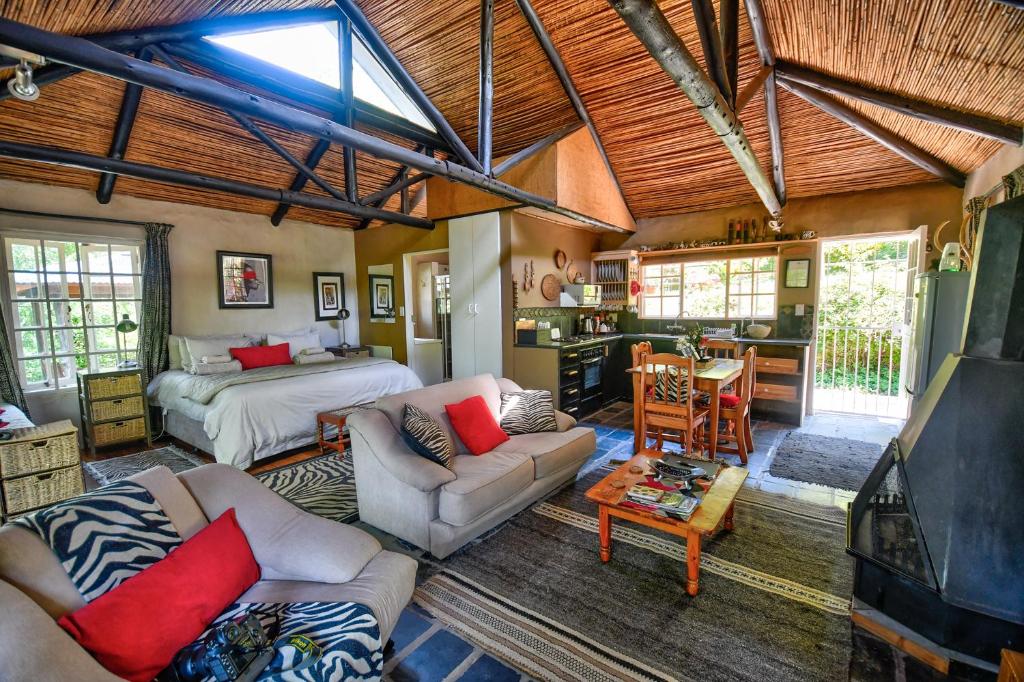 a bedroom with a bed and a living room at Maple Grove in Hogsback
