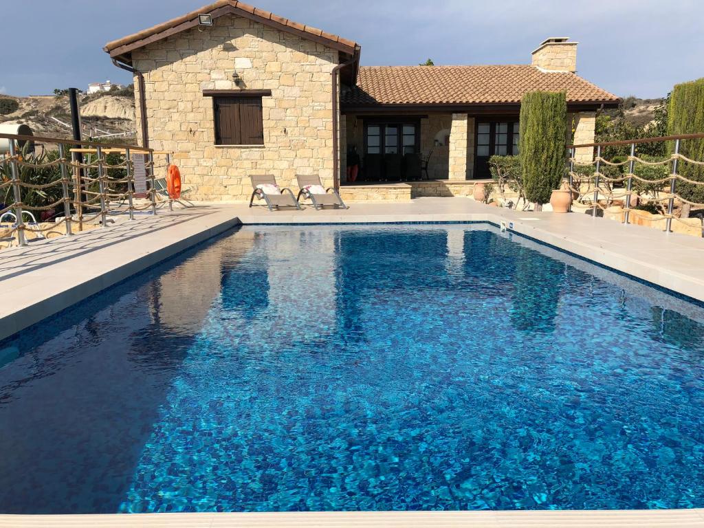 a swimming pool with blue water in front of a house at Paradise Traditional House in Maroni