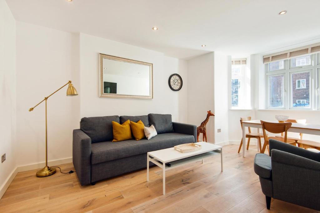 uma sala de estar com um sofá e uma mesa em Notting Hill Flat near Portobello Road :) em Londres