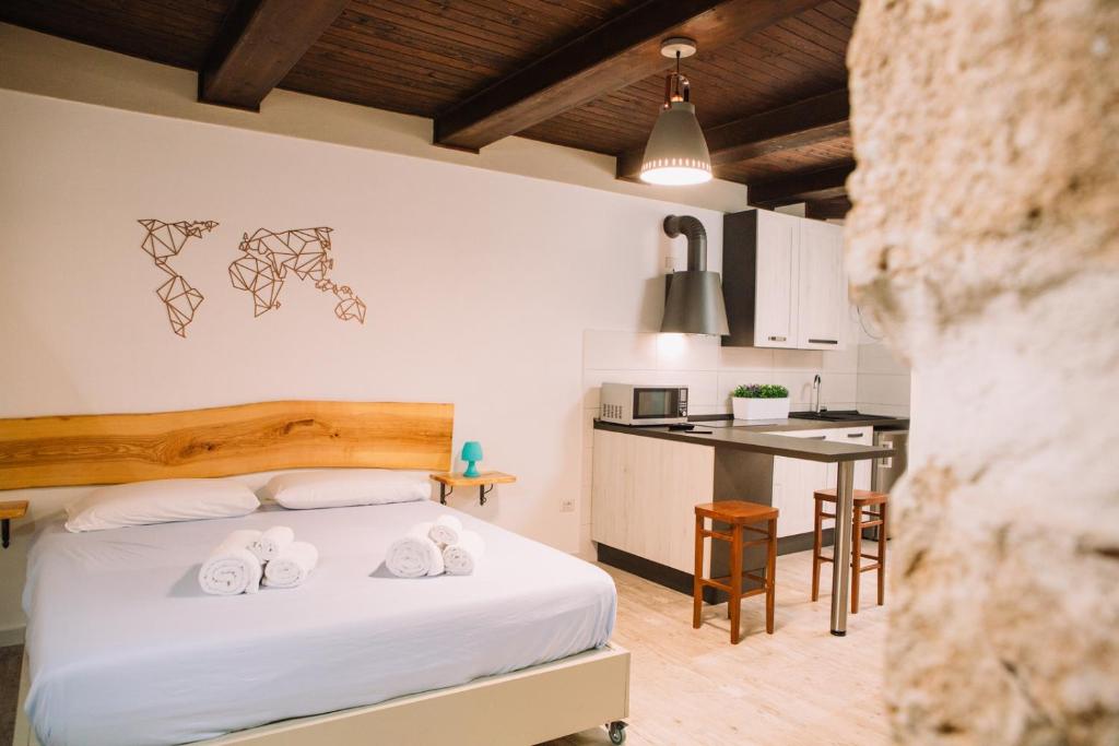 ein Schlafzimmer mit einem Bett mit zwei Handtüchern darauf in der Unterkunft Apartment in the Heart of the City in Alghero