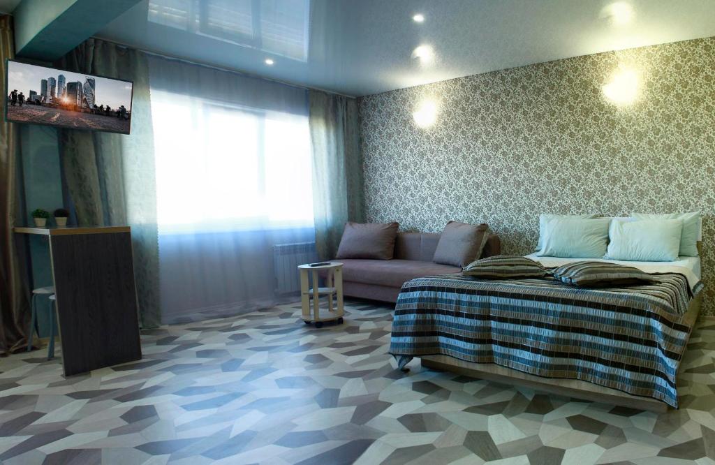 ビイスクにあるАпартаменты "Добрые Сутки" на Мартьянова 63のベッドルーム(ベッド1台、ソファ付)