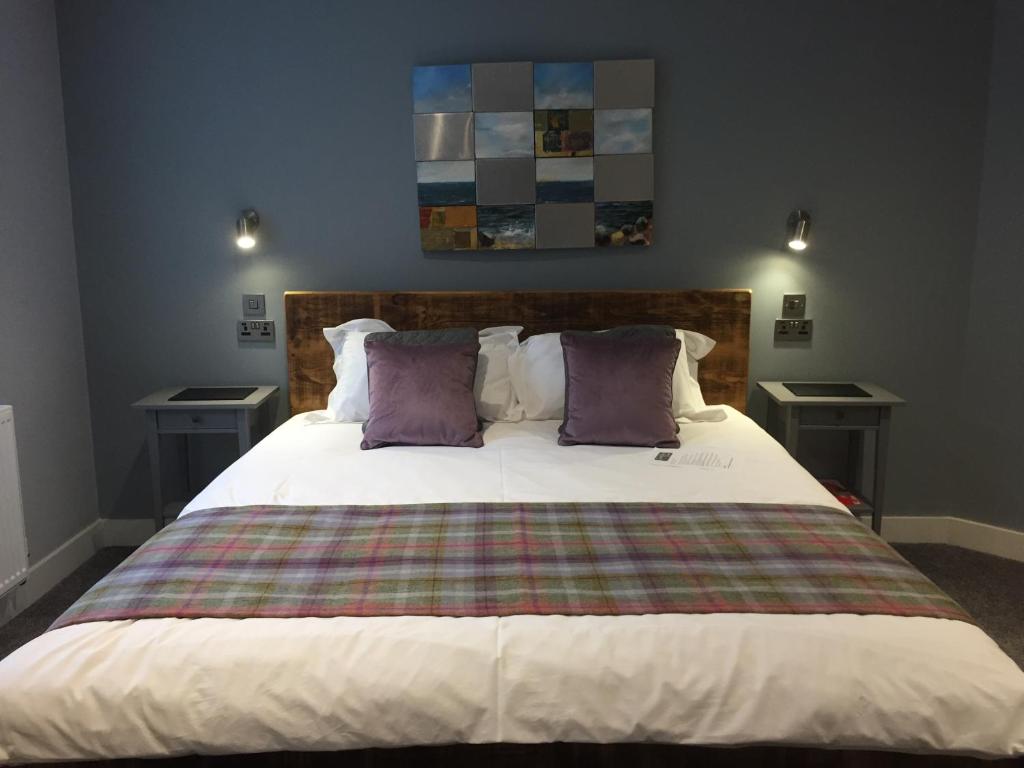 a bedroom with a large bed with purple pillows at Lymm Boutique Rooms in Lymm