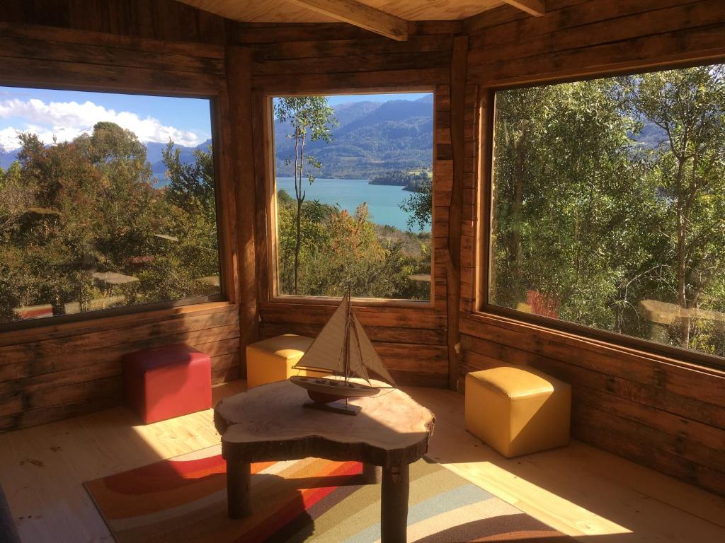 Habitación con ventanas grandes y vistas al lago. en Patagonia Nativa, en Cochamó