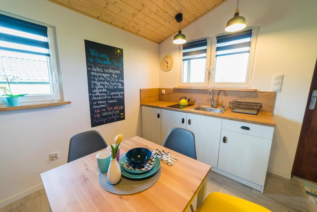 a kitchen with a wooden table and a dining room at Strumyk Marzeń in Mikołajki