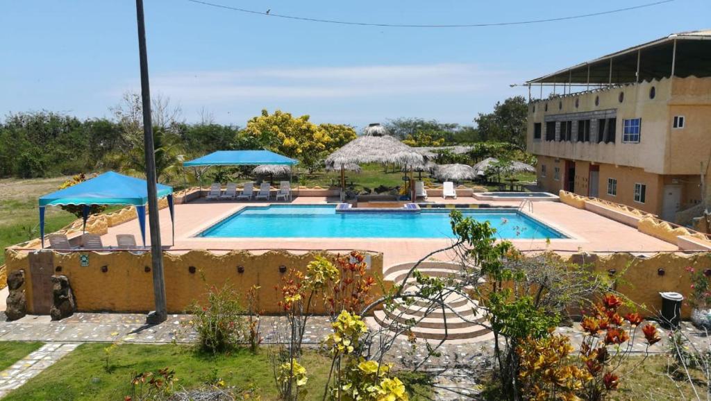 una gran piscina con sombrillas junto a un edificio en Hosteria Mar de Plata, en Cabuyal