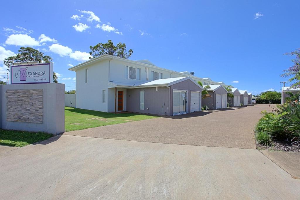 a row of houses on a street with a sign at Alexandra Apartments in Bundaberg