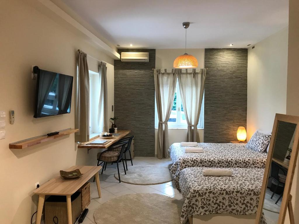 Habitación pequeña con 2 camas, escritorio y mesa. en Flight Apartments Airport by Airstay en Spáta