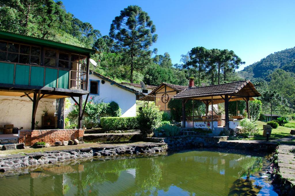 ein Haus mit einem Teich davor in der Unterkunft Meson Hotel in Visconde De Maua