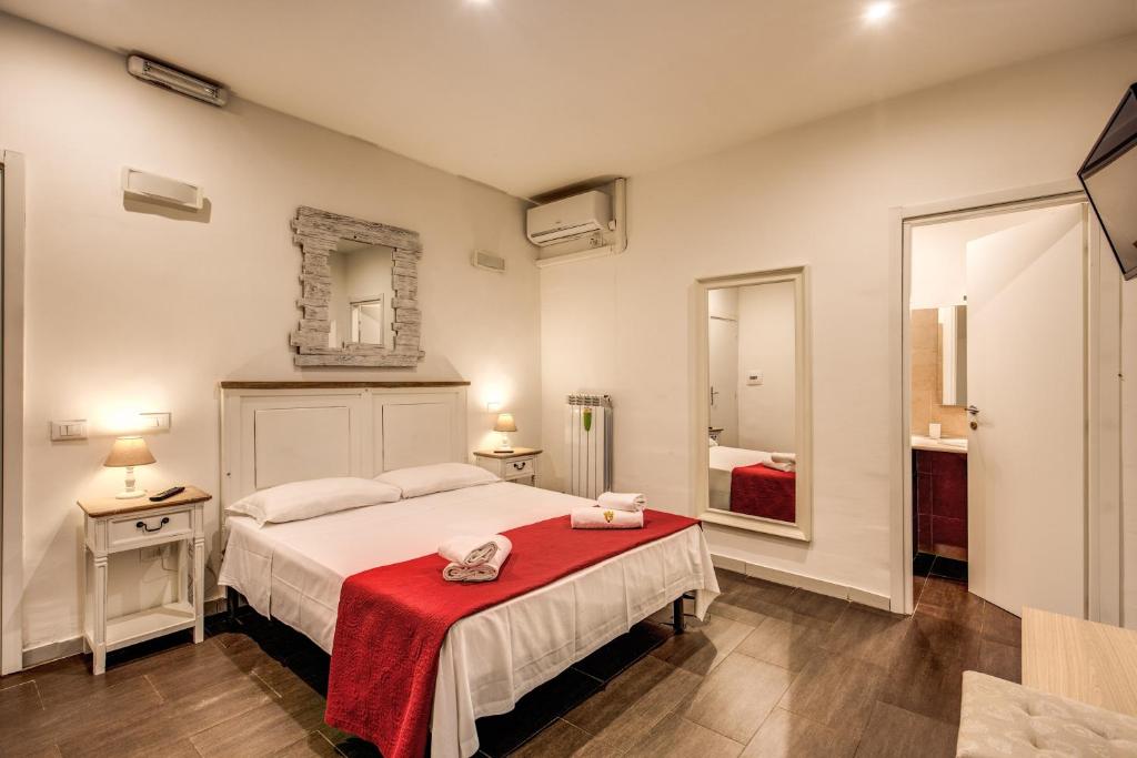 um quarto com uma cama com um cobertor vermelho em Magenta Collection Del Grande 52 em Roma