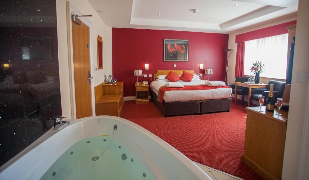 um quarto de hotel com uma cama e uma banheira em Adelphi Portrush em Portrush