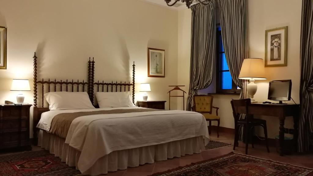 um quarto com uma cama, uma secretária e uma televisão em B&B Castello di Camerletto em Caselette