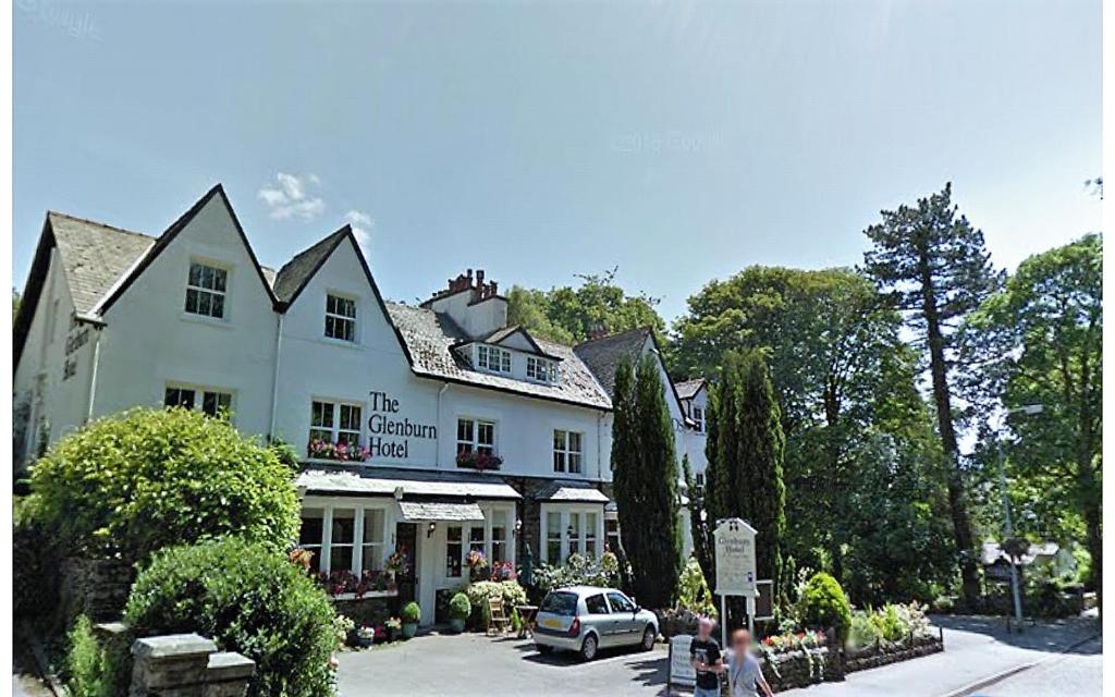 a large house with a large window and lots of trees at Glenburn Guest House in Windermere