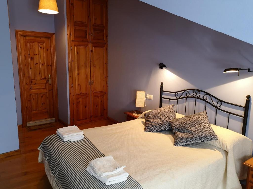 a bedroom with a large bed with two pillows at Casa Guela Niembro in Niembro