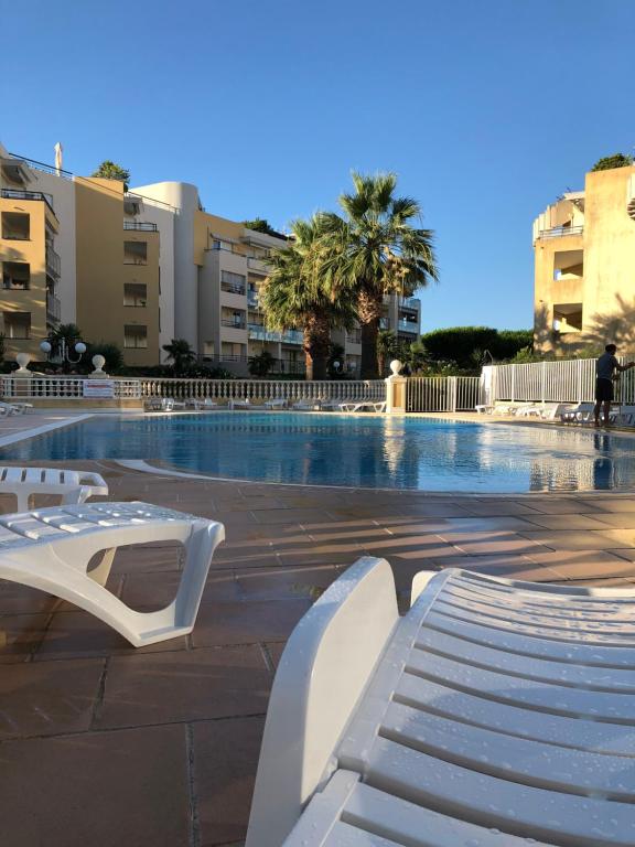 une piscine avec un banc blanc dans une ville dans l'établissement Front beach Luxury near Nice airport, à Cagnes-sur-Mer