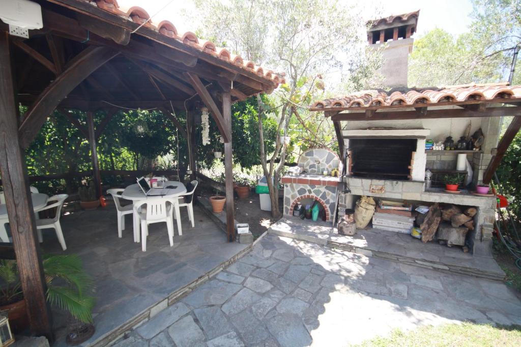 an outdoor patio with a fireplace and a table at Villa Angela in Vourvourou