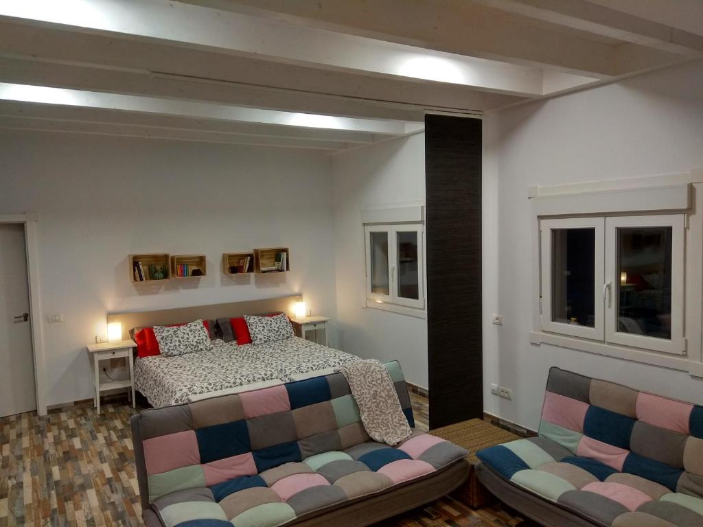 um quarto com uma cama, um sofá e janelas em San Diego 22 em San Cristóbal de La Laguna