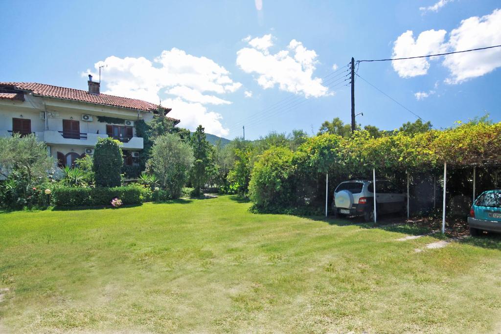 a yard with a house and a car parked at Villa Angela in Vourvourou
