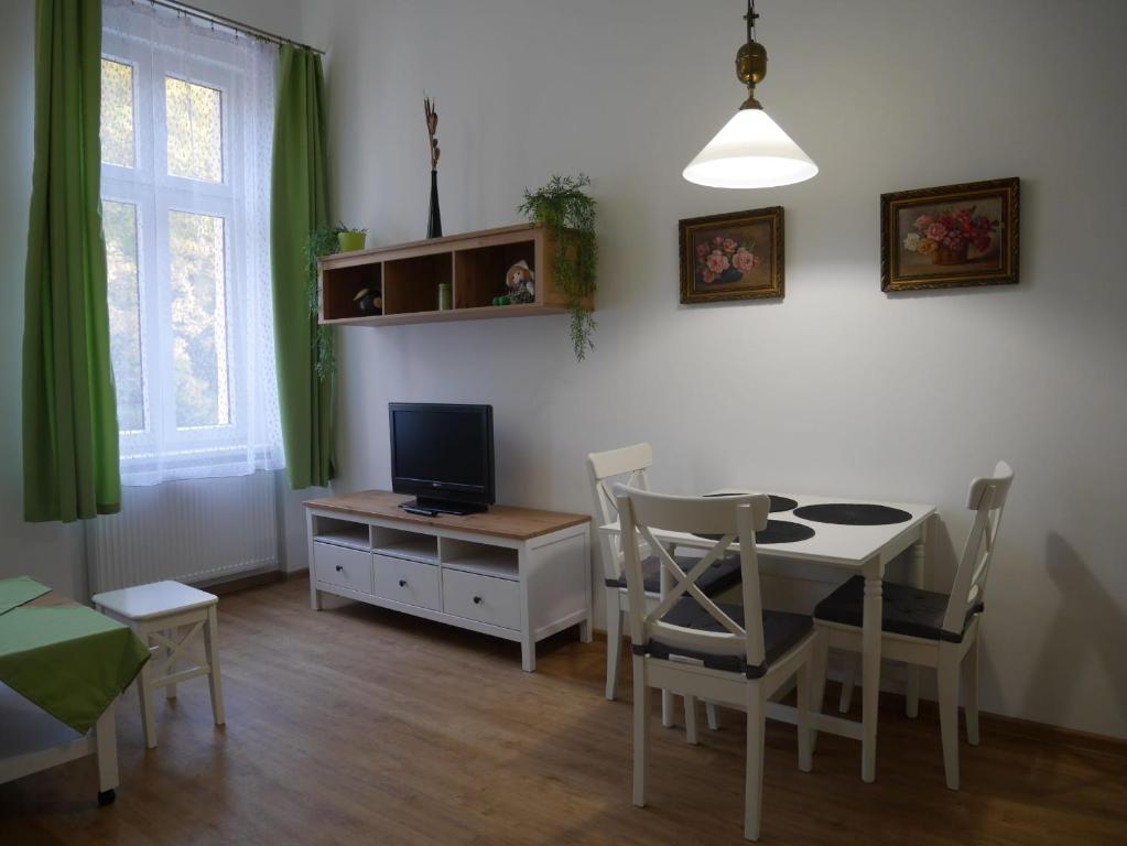 a living room with a dining room table and a television at Moskevská 40 in Karlovy Vary