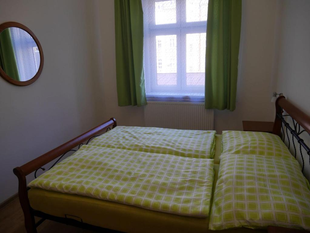 a bed in a bedroom with a window and a mirror at Moskevská 40 in Karlovy Vary