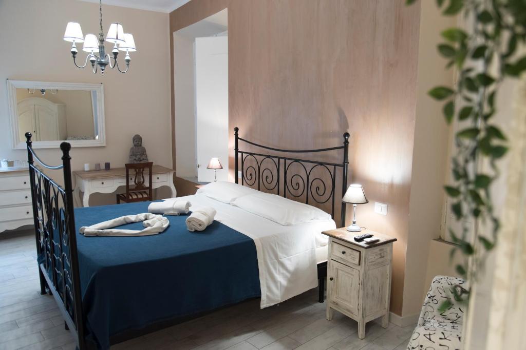 una camera da letto con un letto con un piumone blu e uno specchio di Baldassini Suites a Roma