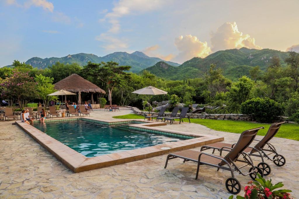 une piscine dans un complexe avec des montagnes en arrière-plan dans l'établissement El Pedregal - Hotel en la Naturaleza, à Álamos