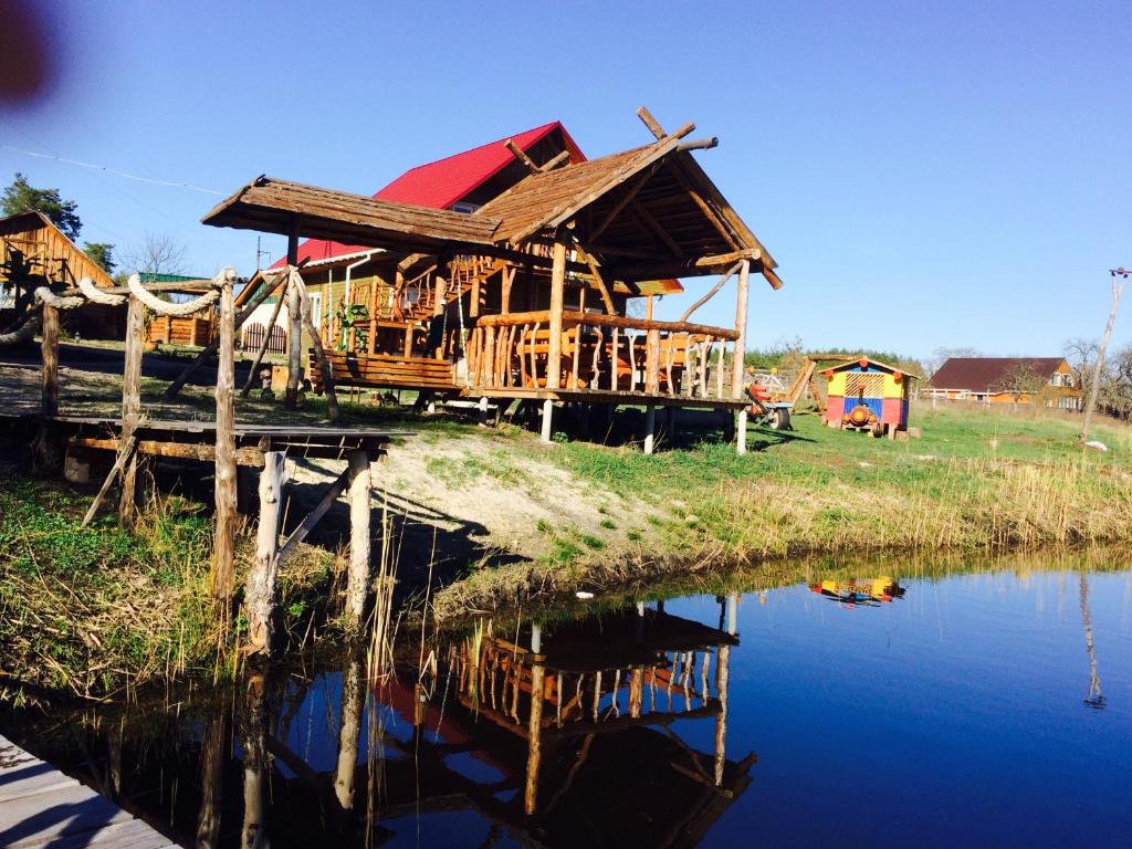 a wooden house next to a body of water at Verhnie Dubai in Vysshaya Dubechnya