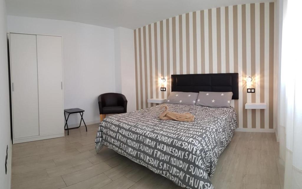 a bedroom with a large bed and a chair at Málaga Alcolea in Málaga