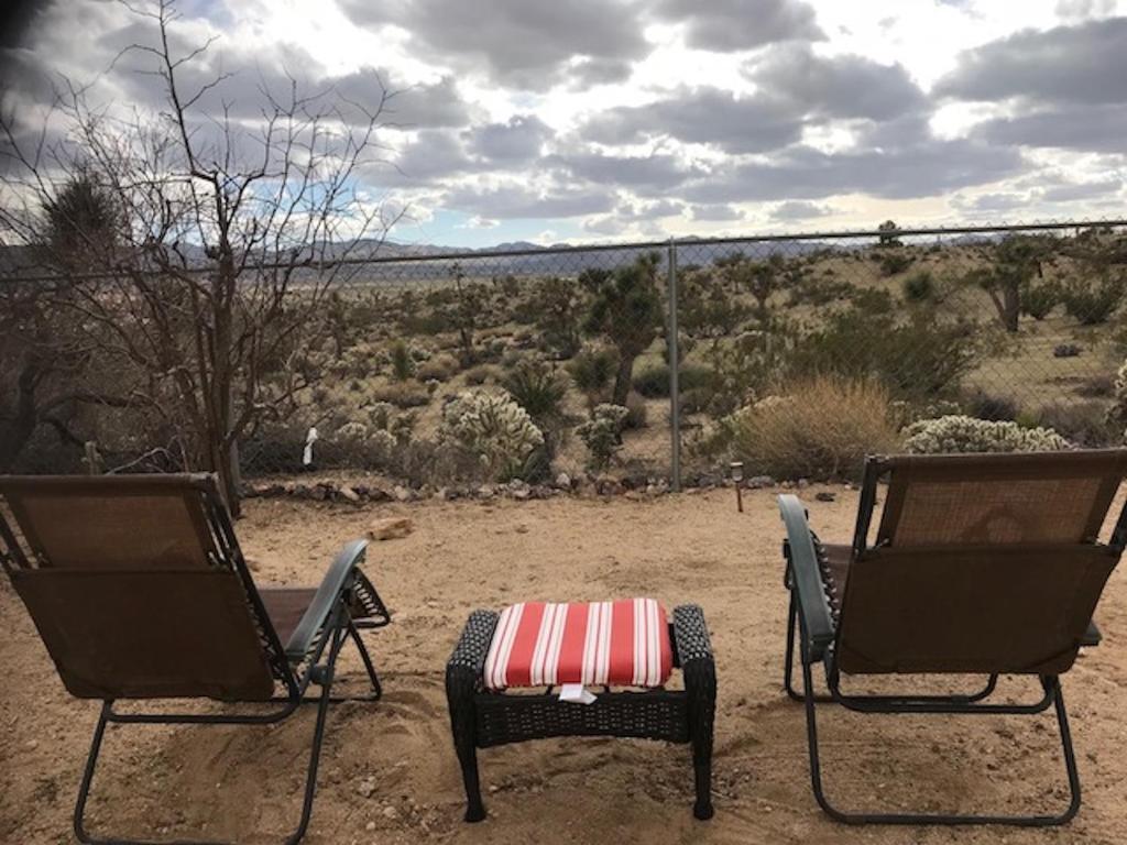 dos sillas con una mesa en medio de un campo en Desert Oasis - Joshua tree peaceful retreat Home, en Yucca Valley