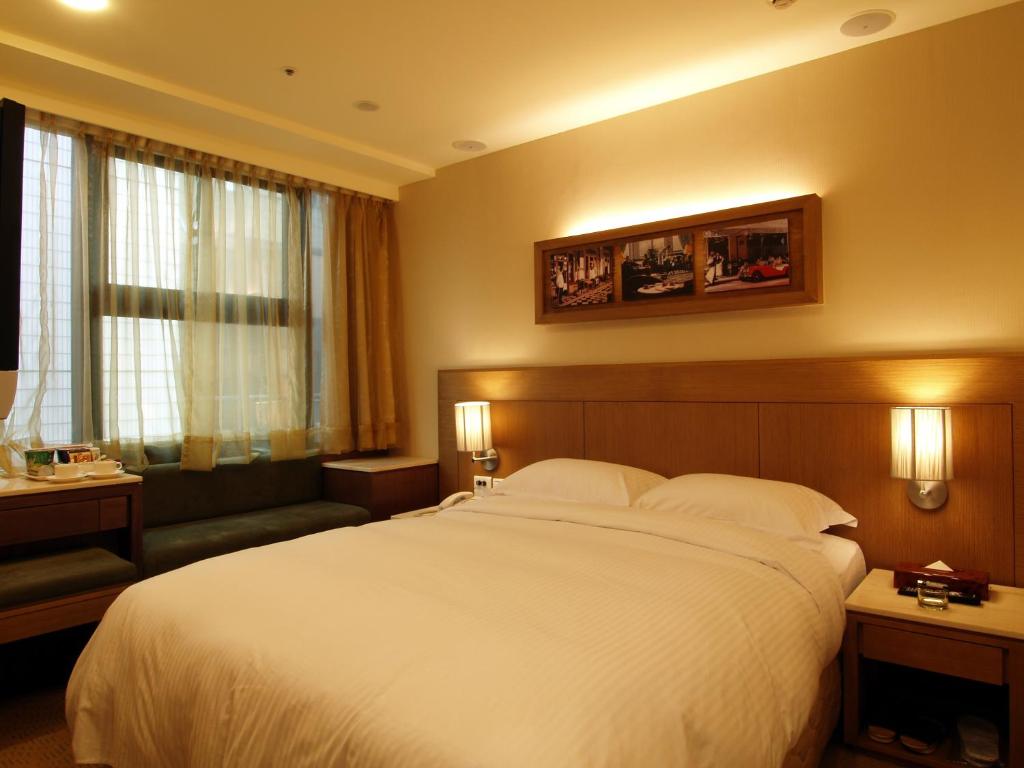 a hotel room with a large bed and a couch at 東鑫商務旅館Eastern Star Hotel in Taipei