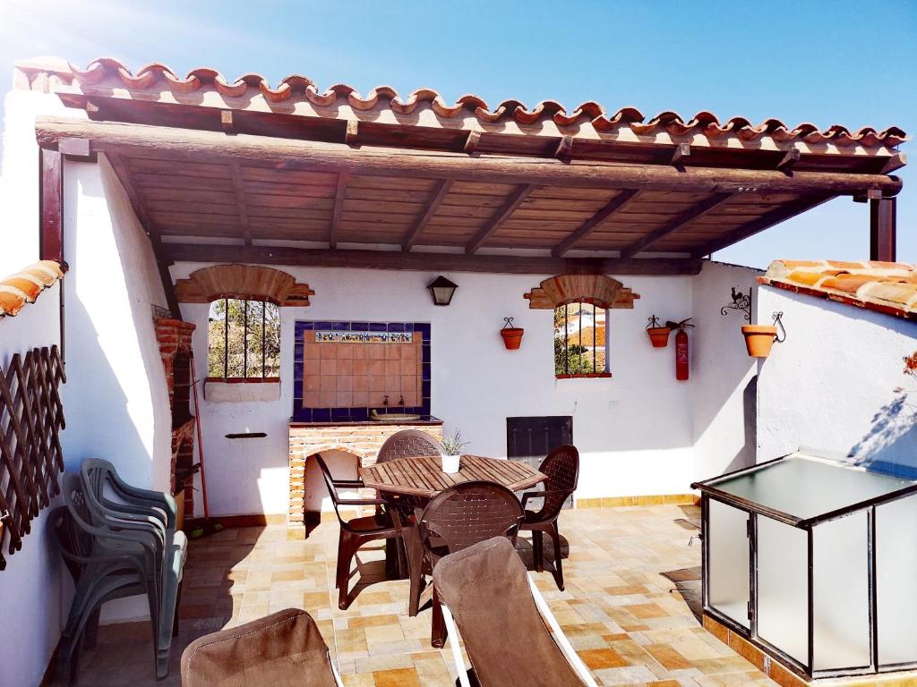 un patio con mesa de madera y sillas en Casa Las Torres, en Medina de las Torres