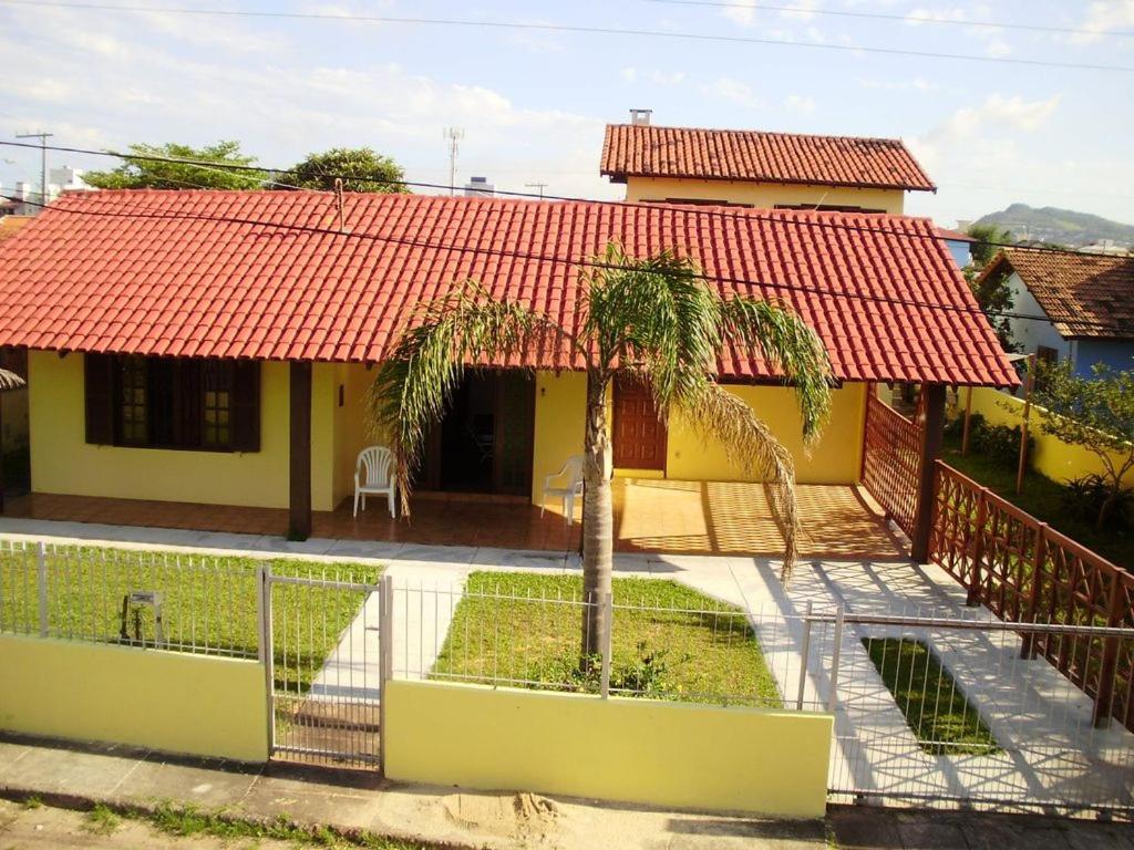 una pequeña casa amarilla con techo rojo en Casa na praia dos Ingleses para até 12 pessoas, en Florianópolis