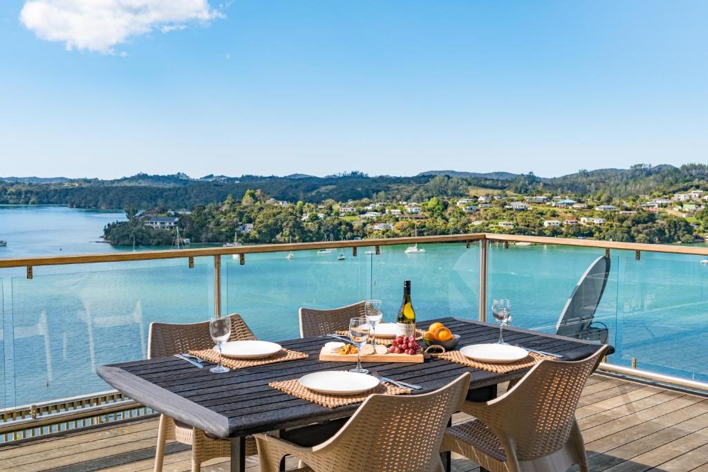 a dining table on a deck with a view of the water at Marina Cove Bay of Islands in Opua