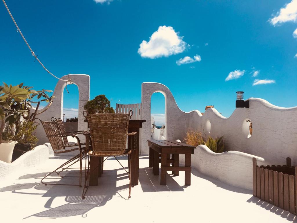 a patio with chairs and a table on a fence at Deer Moon Hostel in Kenting