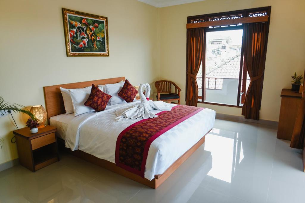 - une chambre avec un grand lit et une fenêtre dans l'établissement Deko House, à Ubud