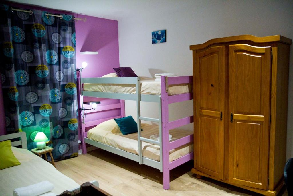 a bedroom with two bunk beds with purple walls at Gîte Les Bourdettes in Auvillar
