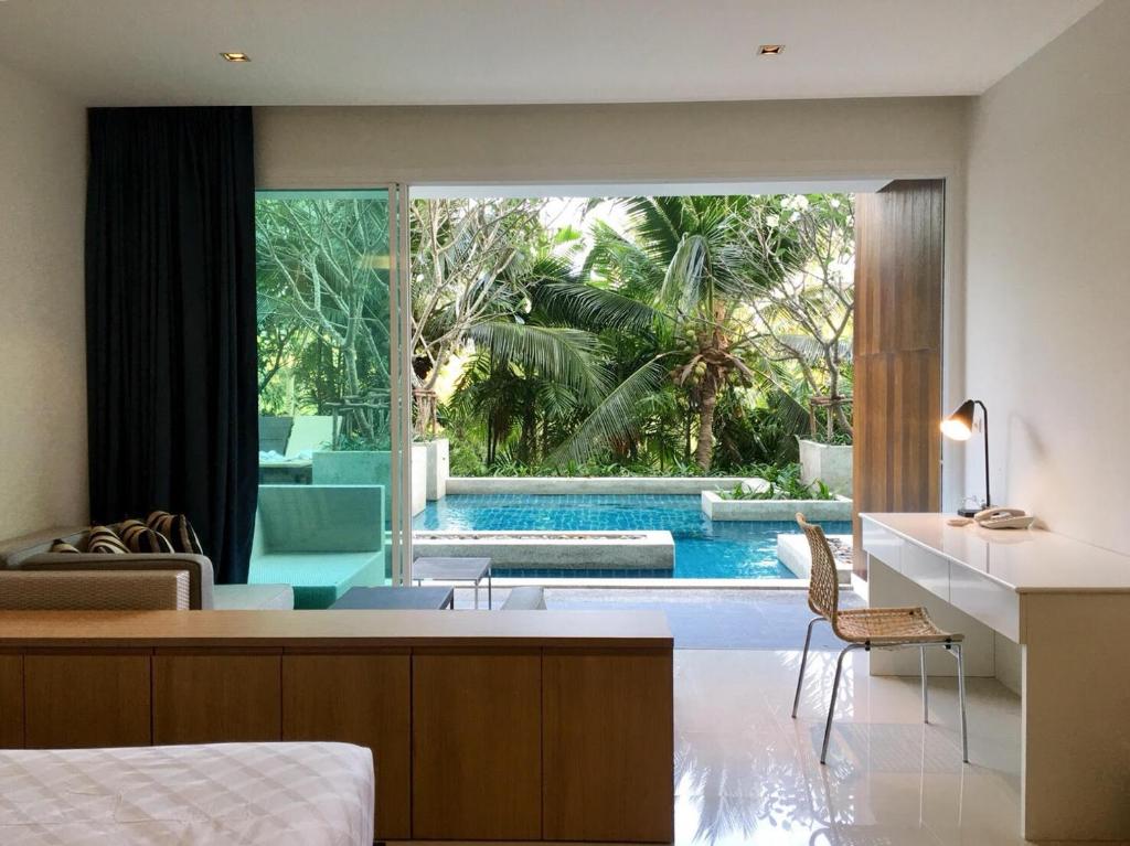 a bedroom with a view of a swimming pool at Mida de Sea Residence Hua Hin in Cha Am