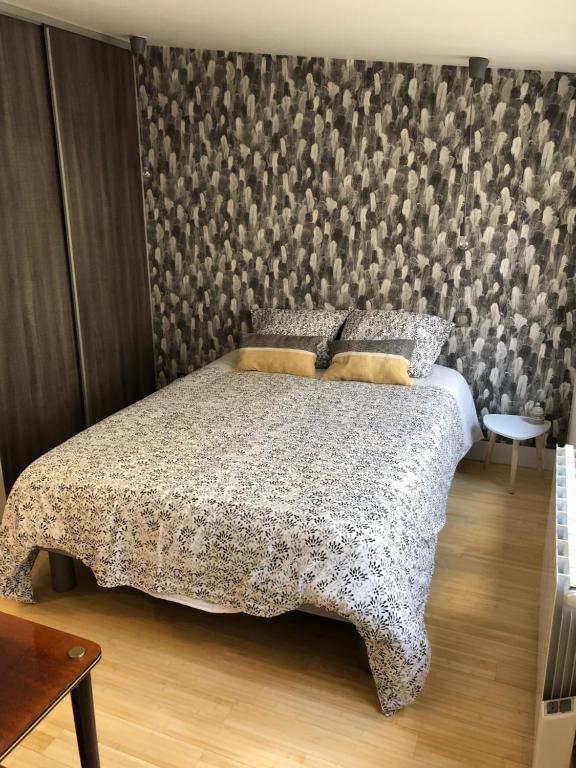 a bedroom with a bed with a patterned wall at appartement place stanislas in Nancy