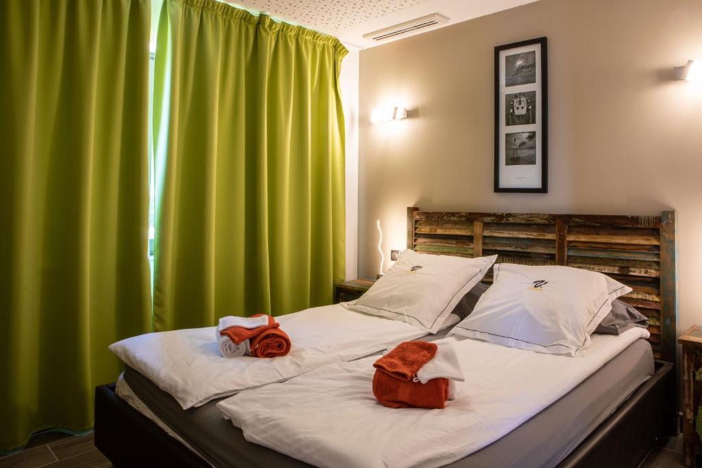Schlafzimmer mit einem großen Bett und grünen Vorhängen in der Unterkunft VbyOnyx in Olmeto