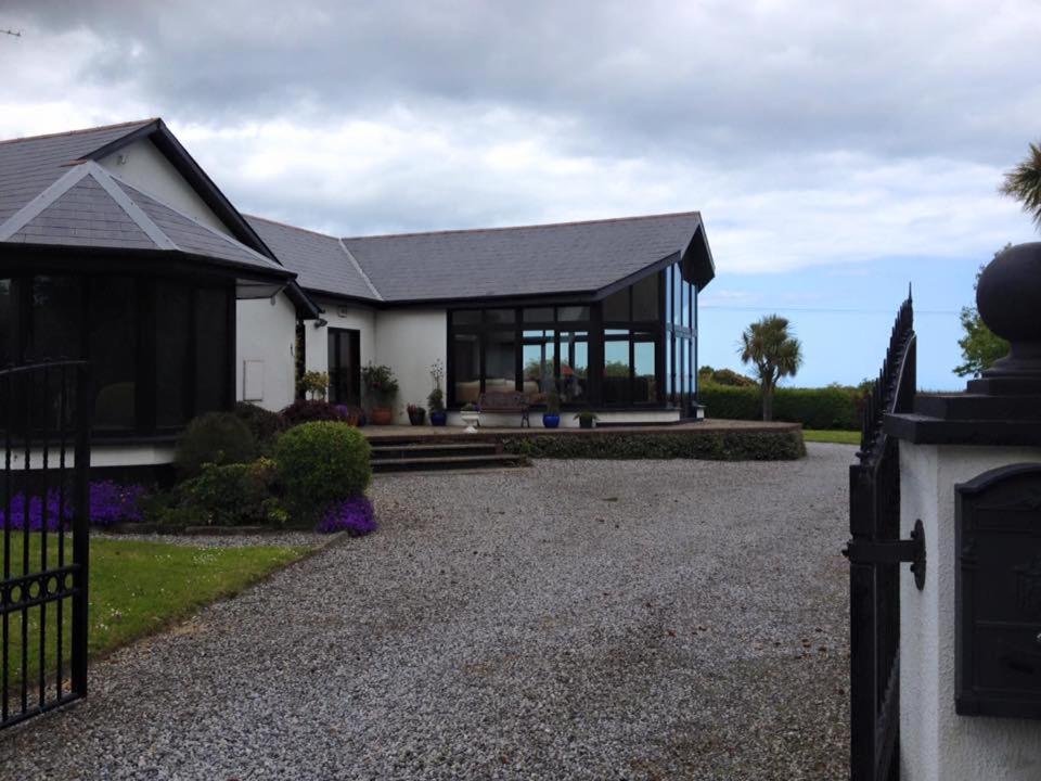 a home with a black and white house with a driveway at ocean view in Wexford