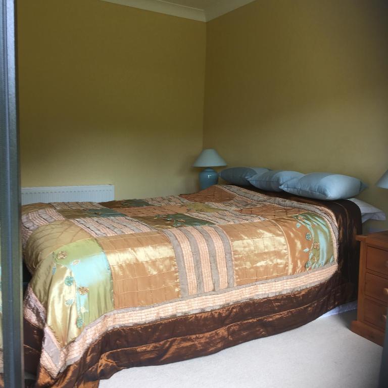 a bedroom with a bed with a bedspread on it at ocean view in Wexford
