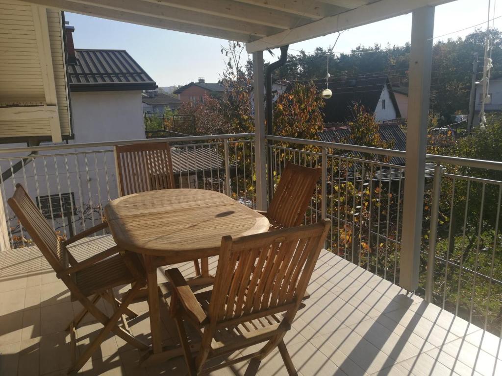 una mesa de madera y 2 sillas en el porche en Peaceful 4-room house in Maribor's green garden, en Maribor