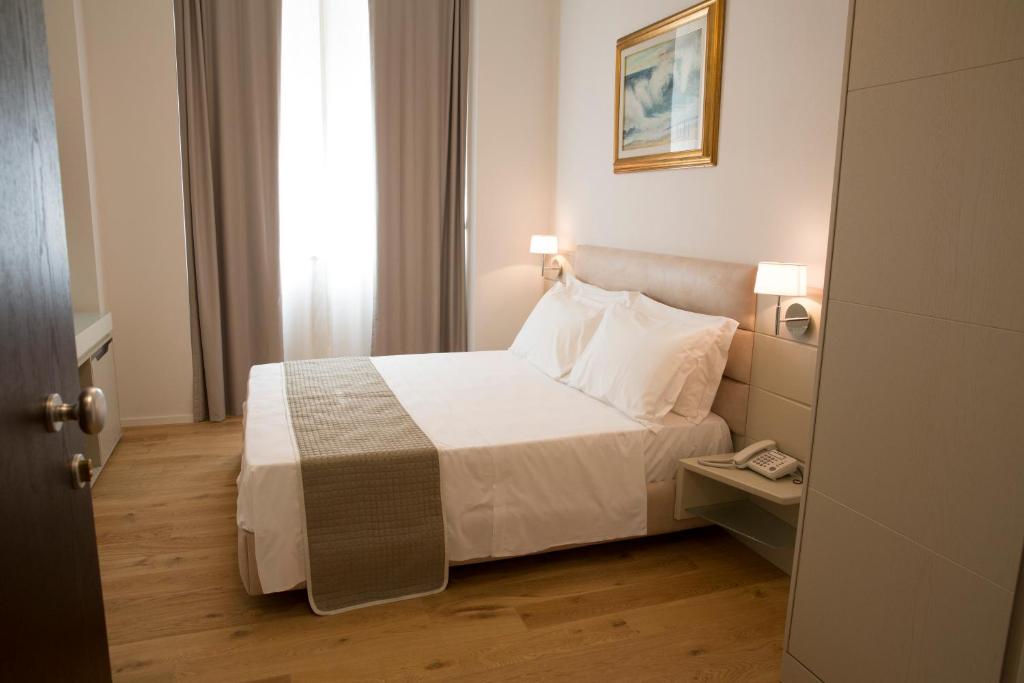 a hotel room with a bed and a window at Boutique Hotel Enia in Prato